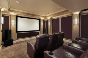 A theater room with lounge chairs in a luxury home